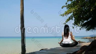 4K. 在暑假期间，亚洲女人坐在海上的木桥上练习集中注意力